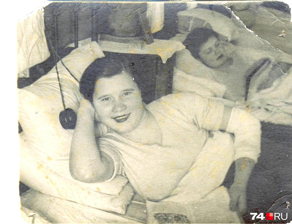 Вот полная версия снимка из госпиталя. Рядом, на подушке, похоже, лежат наушники, в руках у Надежды книга. Хорошо разглядеть можно и соседку по палате, но имя её, к сожалению, не сохранилось