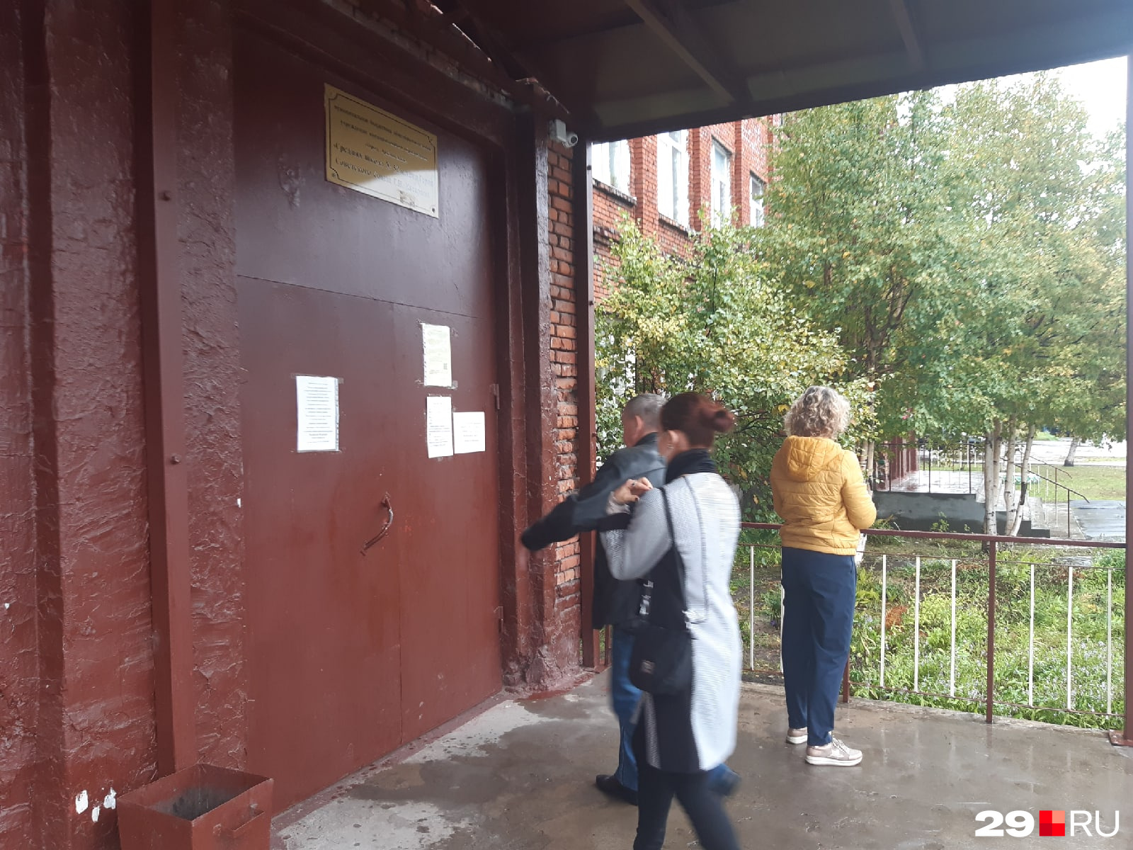 В школе № 52 в Соломбале находятся сразу два избирательных участка: 113 и 115. Люди подходят с зонтиками В школе № 52 в Соломбале находятся сразу два избирательных участка: 113 и 115. Люди подходят с зонтиками