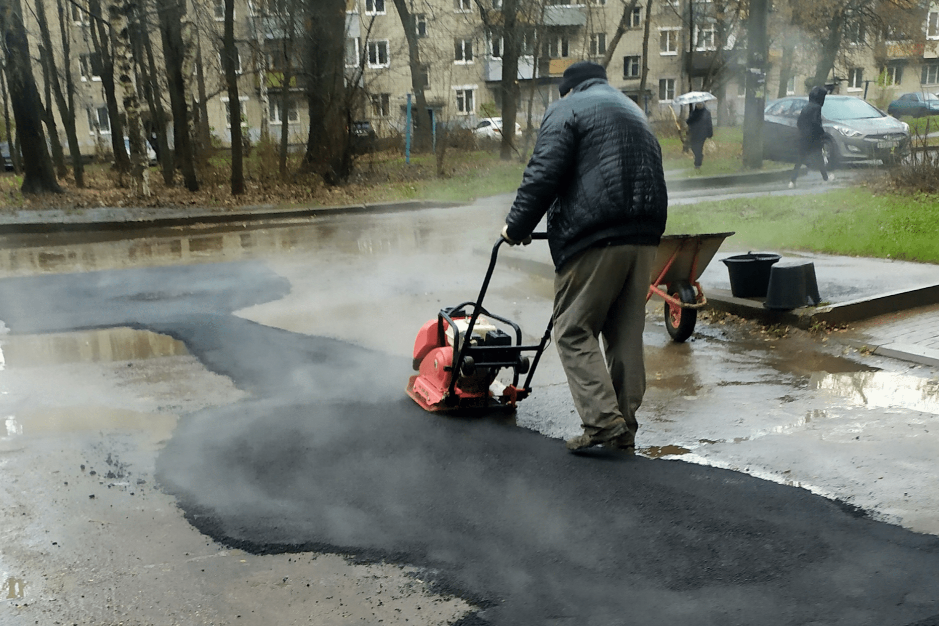 Кладут асфальт в дождь