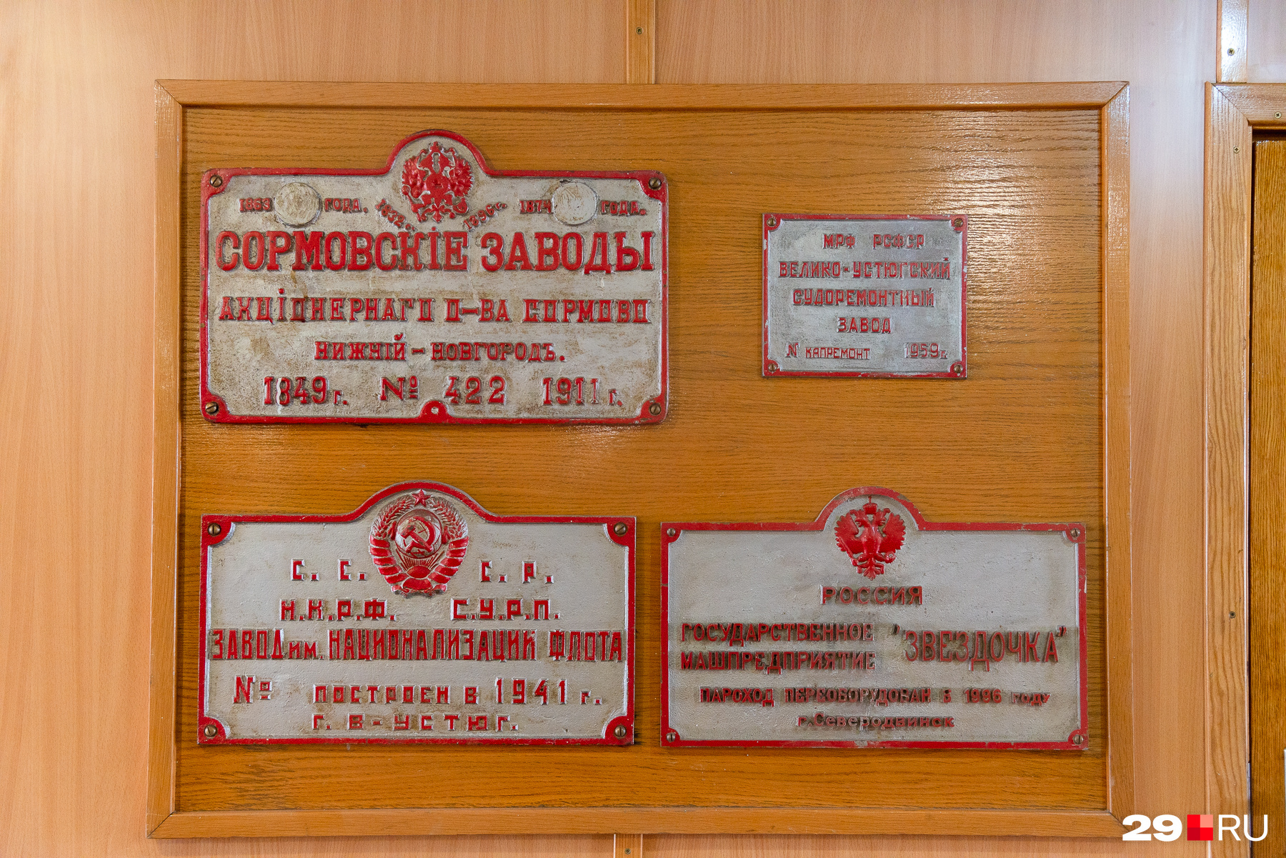 На стене висят исторические таблички разных лет — самой старой из них 109 лет