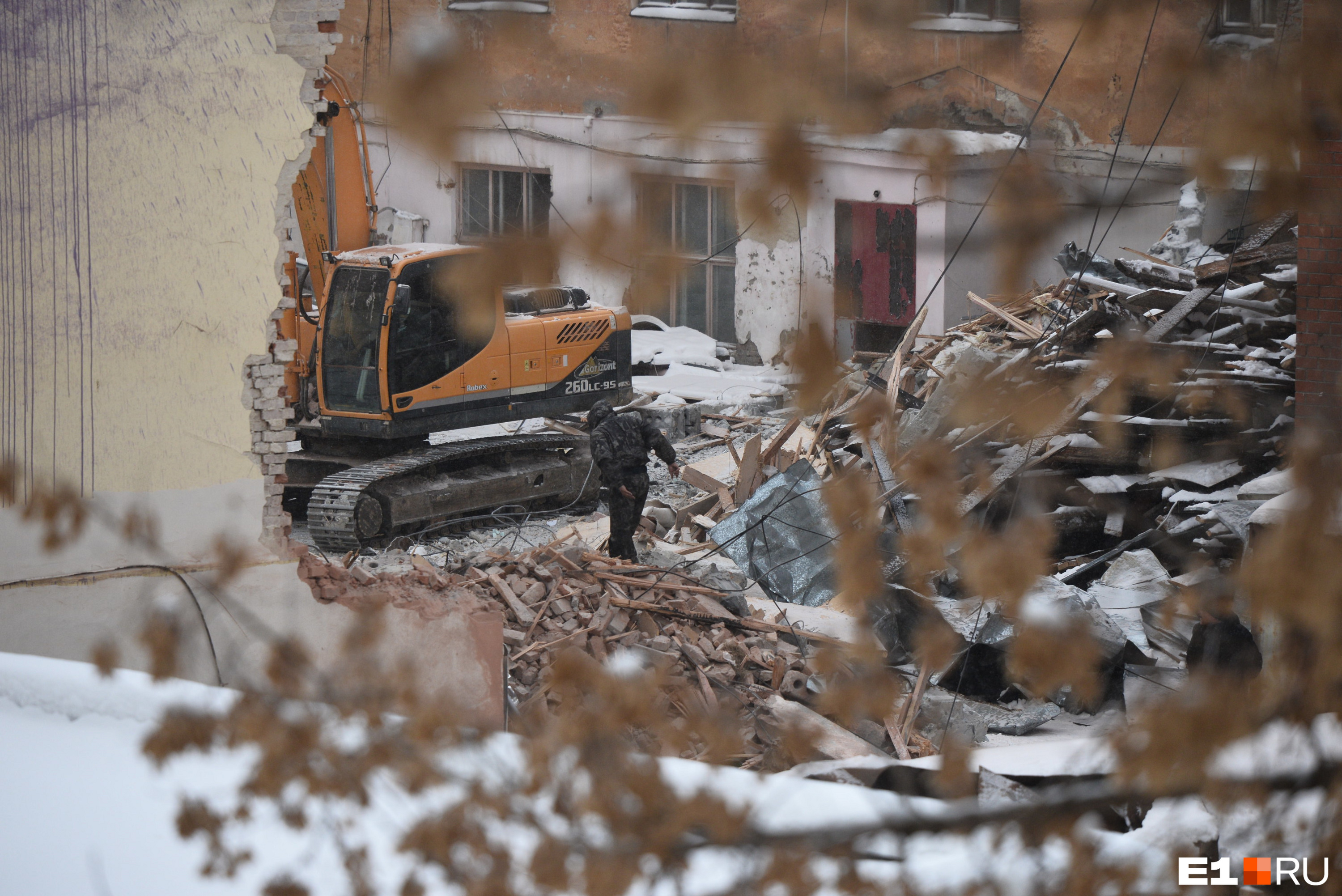 Бульдозер разравнивает груды строительного лома