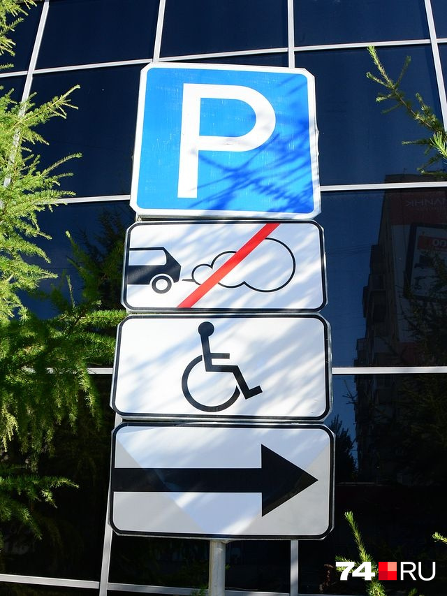 Парковка на улице Коммуны в 2016 году: комбинация знака «Парковка» и «Инвалид» с такой стрелкой обозначает, что инвалидная стоянка находится где-то вдалеке справа от знака. Обозначать так направление действия нельзя