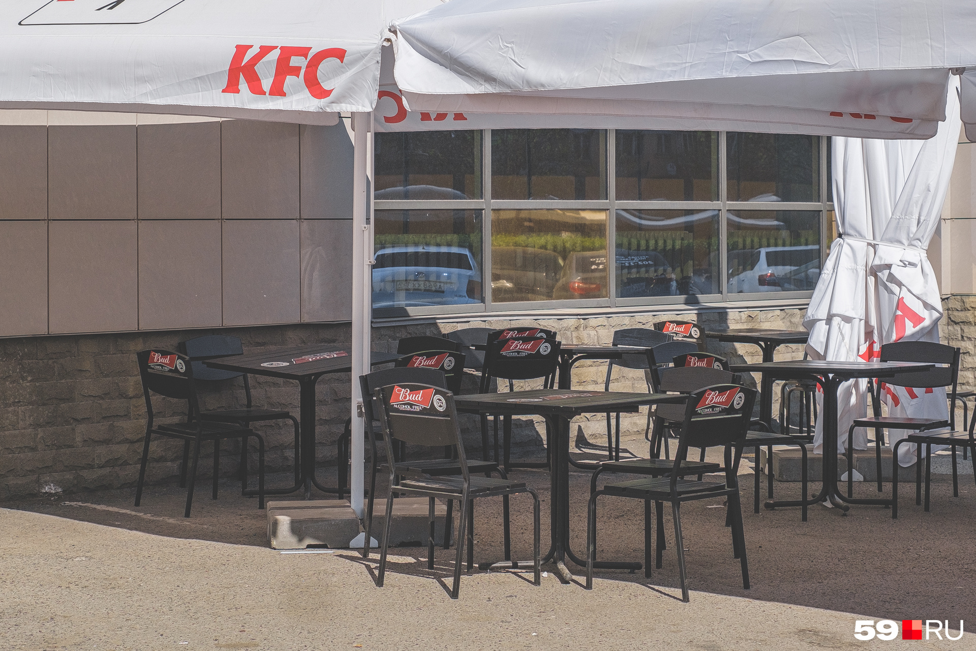 Столы под зонтиками ресторана быстрого питания KFC возле «Пирамиды» на Крисанова, 12а