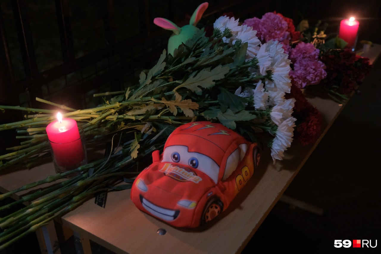 К мемориалу несут игрушки, цветы и свечи К мемориалу несут игрушки, цветы и свечи