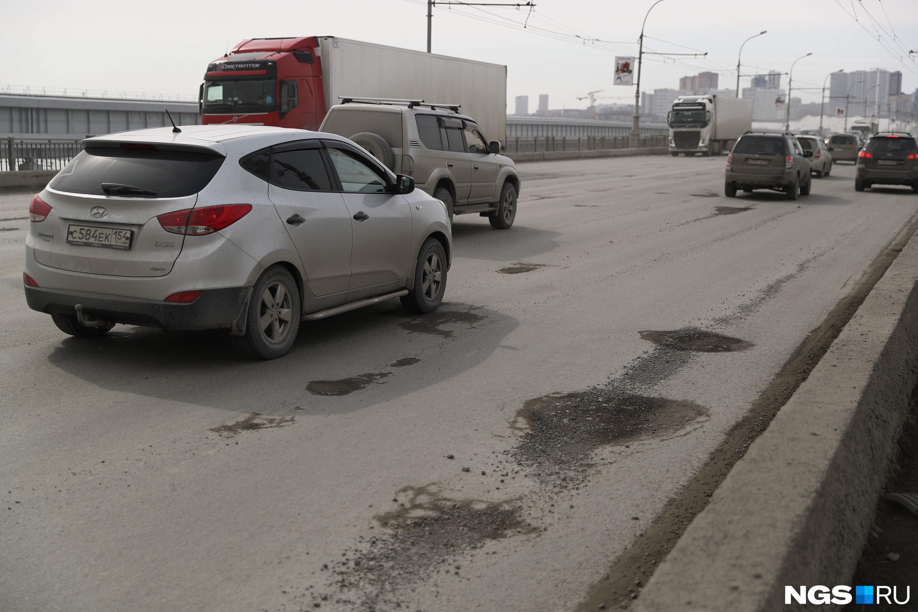 Состояние дорог новосибирск. Ямы на Октябрьском мосту Новосибирск. Ямы на Октябрьском мосту Новосибирск вид сверху. Дыры в Октябрьском мосту Новосибирска.