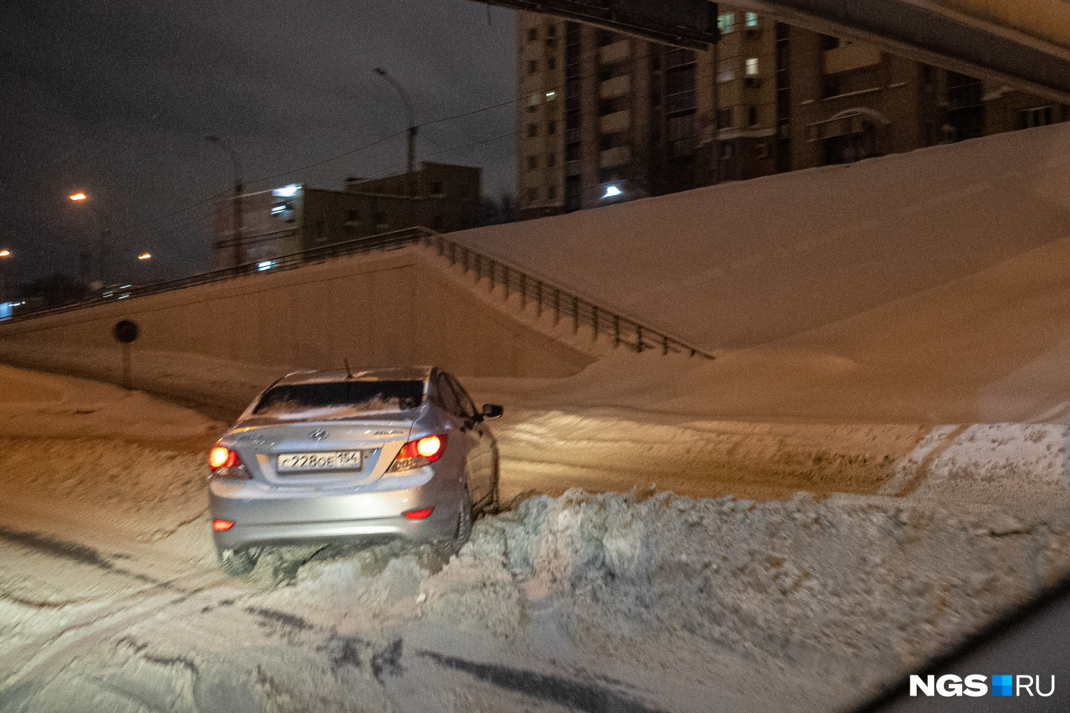 Это улица Ипподромская, и она не чищена совсем. Автомобили просто-напросто застревают в снегу прямо на дороге