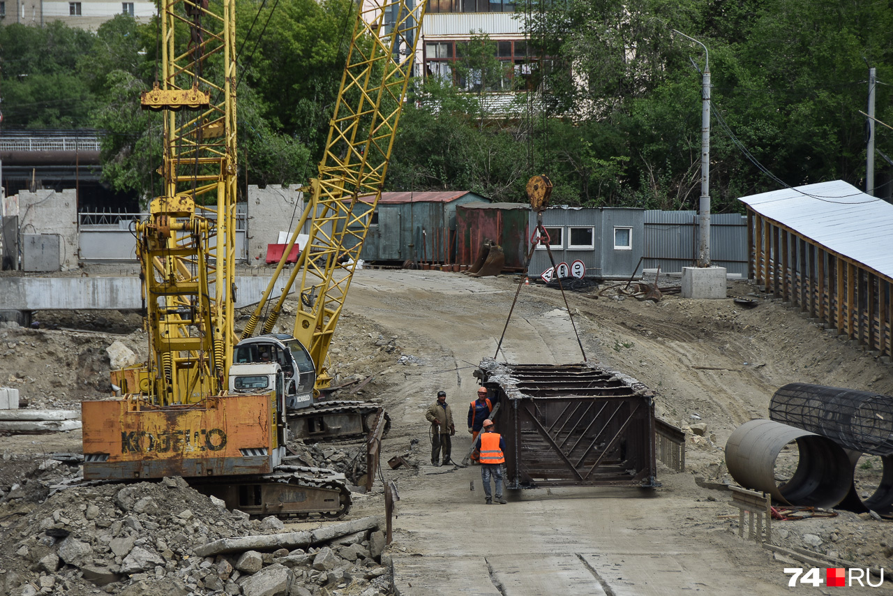 Рабочие грузят металлическую балку старого моста