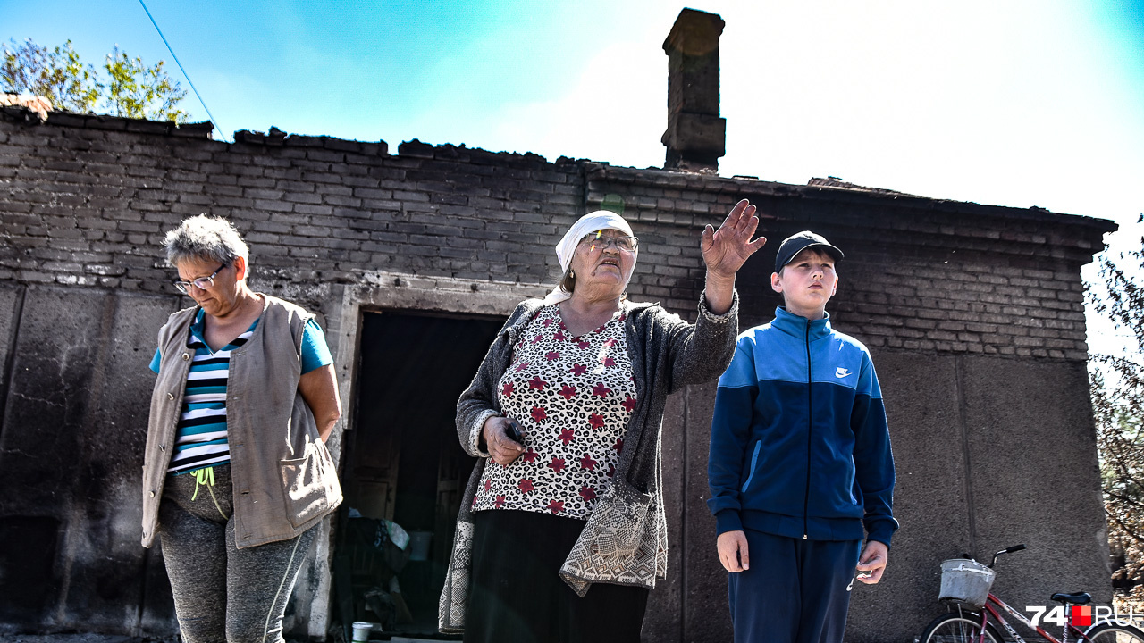 Валентина Павлова с внуком на крыльце дома, которому повезло выстоять. Вот только крыша сгорела полностью