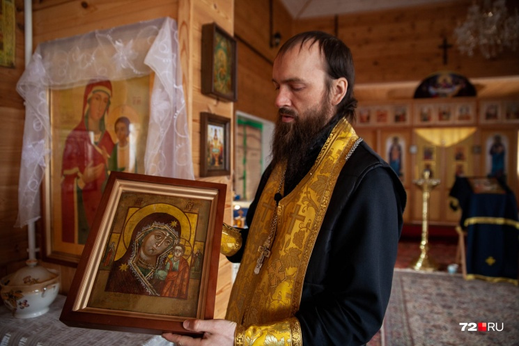 Отец Евгений держит в руках старинную уже отреставрированную икону Казанской Божией Матери
