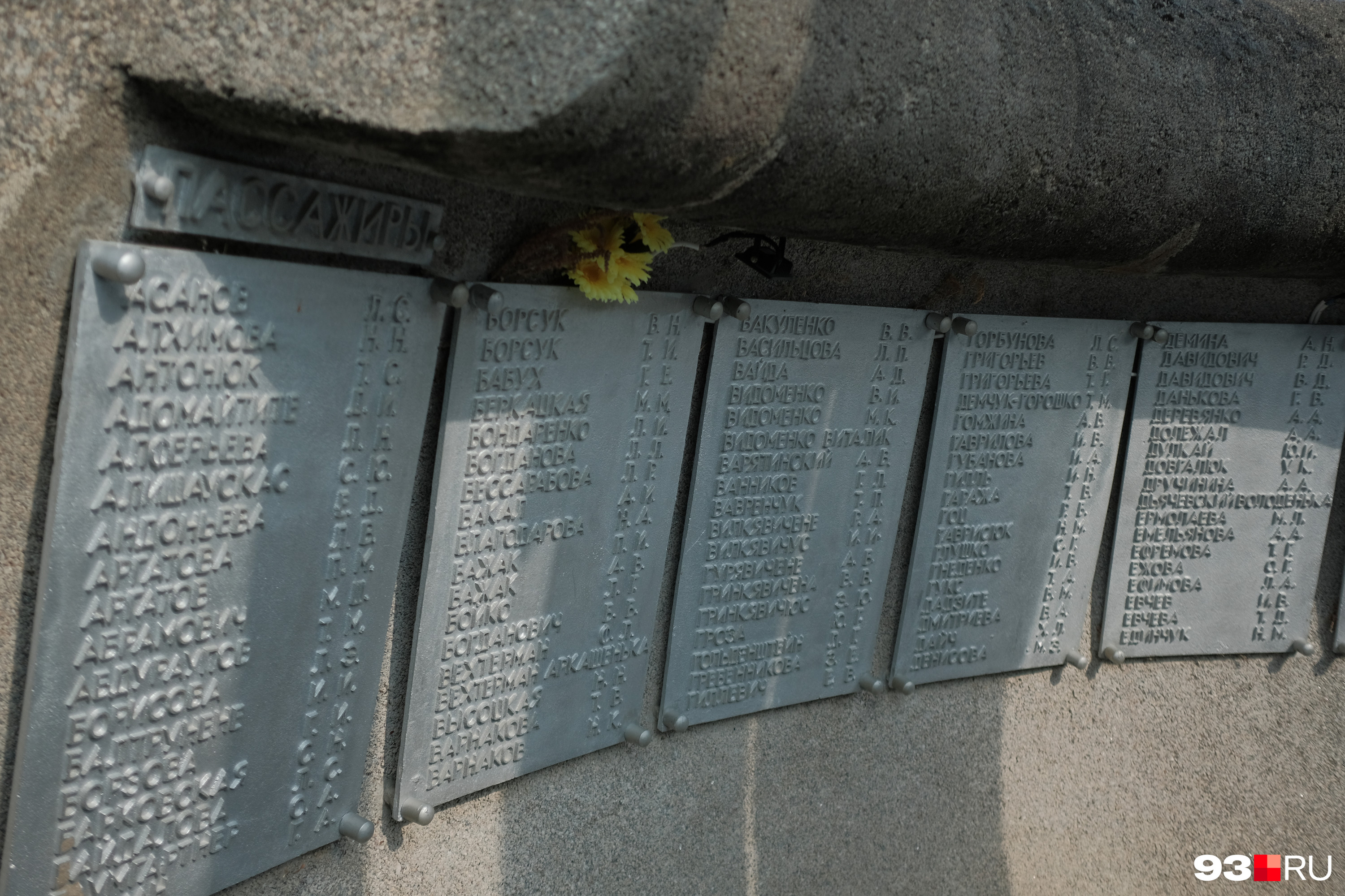 Трубы окаймляет волна из железобетона, к внутренней стороне прикреплены таблички с именами погибших