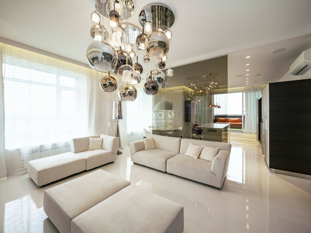 В квартире много белых оттенков и стекла — только взгляните на эту футуристичную люстру в гостиной!