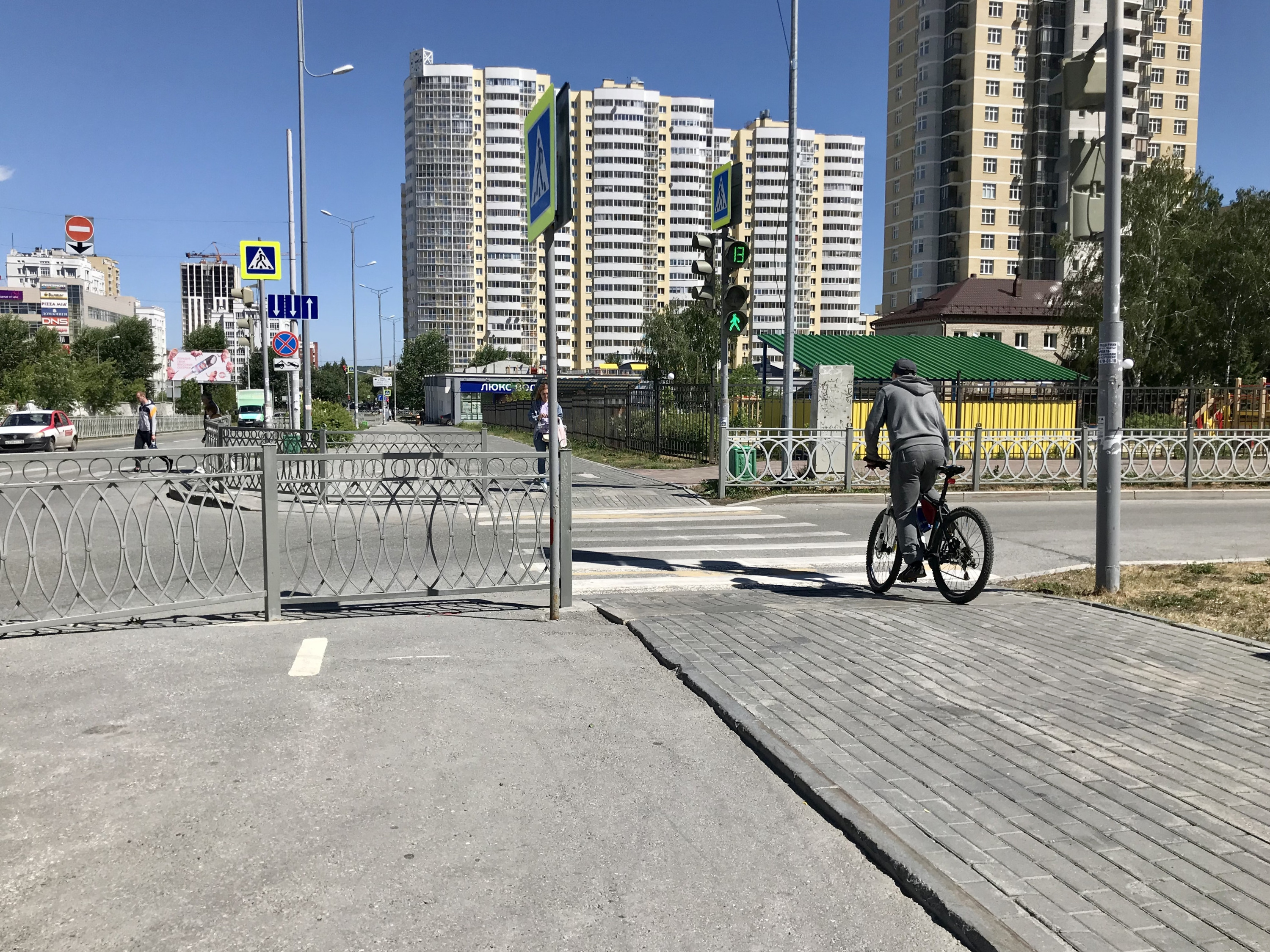 Велодорожка перекрыта забором. Поэтому велосипедист вынужден двигаться по тротуару