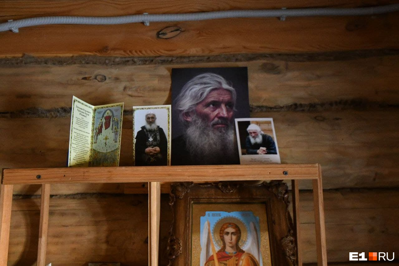 Рядом с иконами стоят портреты отца Сергия