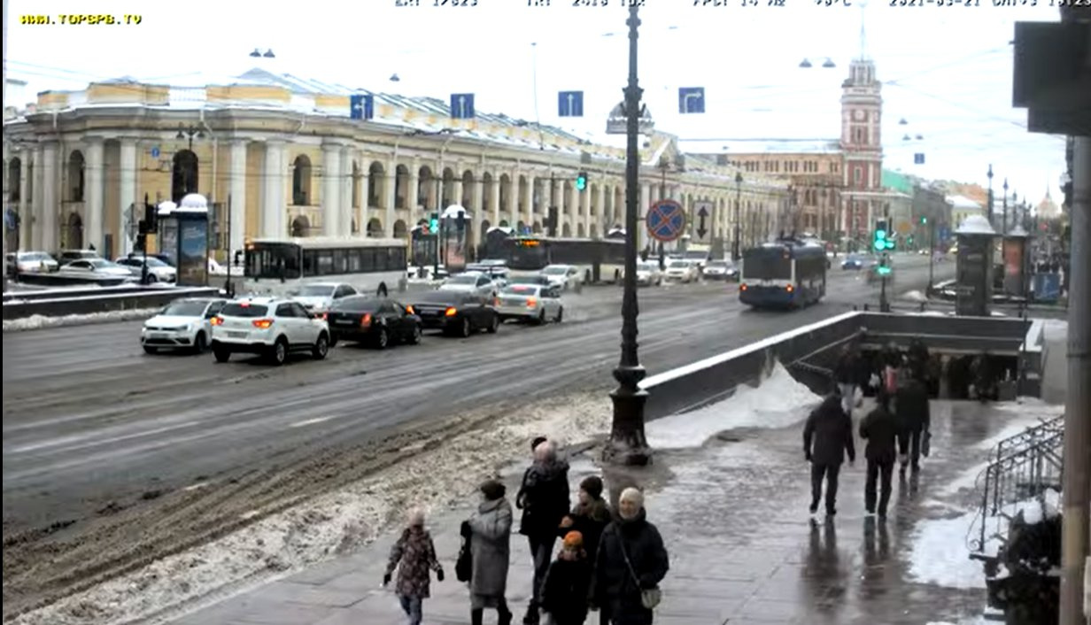 Другой улице. Машина едет по Невскому. Военные машины едут по льду на фоне Петербурга.