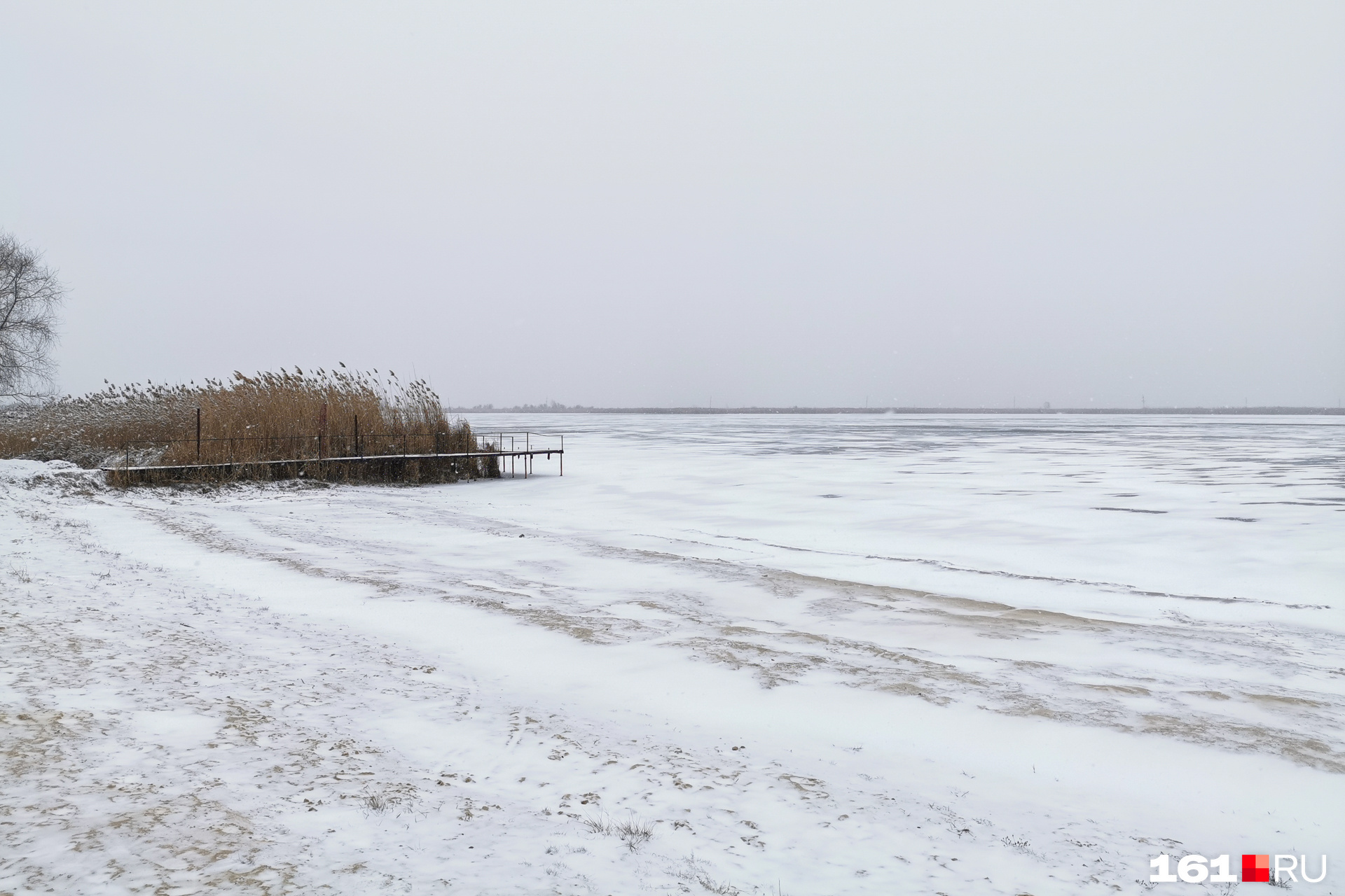 Пляж присыпало снегом, а озеро покрыло тонким льдом