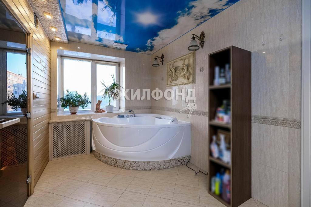 Стену ванной комнаты украшает барельеф, а лежа в джакузи, можно смотреть на небо не только в окне, но и на потолке