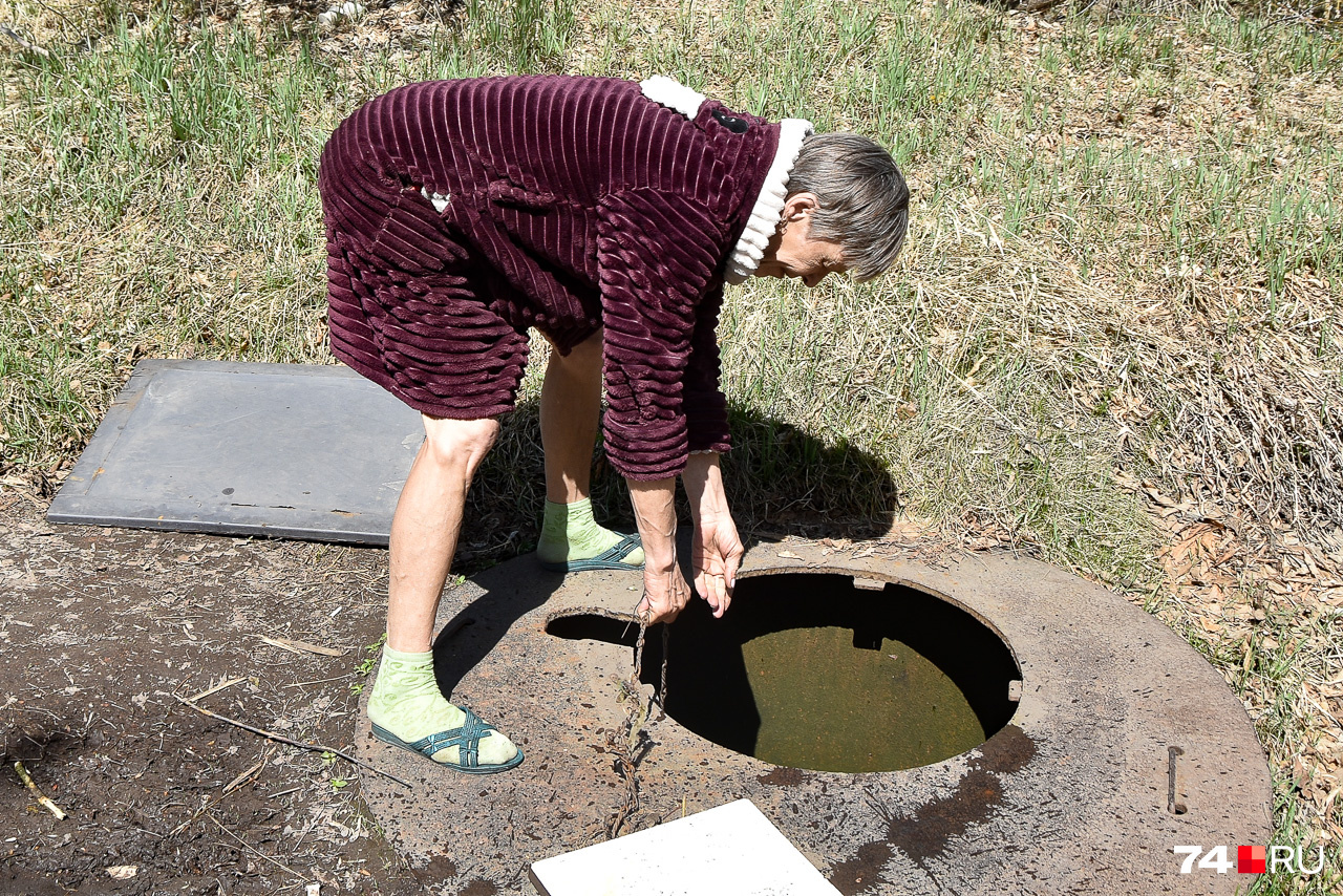 Наталья демонстрирует, как добыть воду из местной скважины, которая не имеет даже колонки