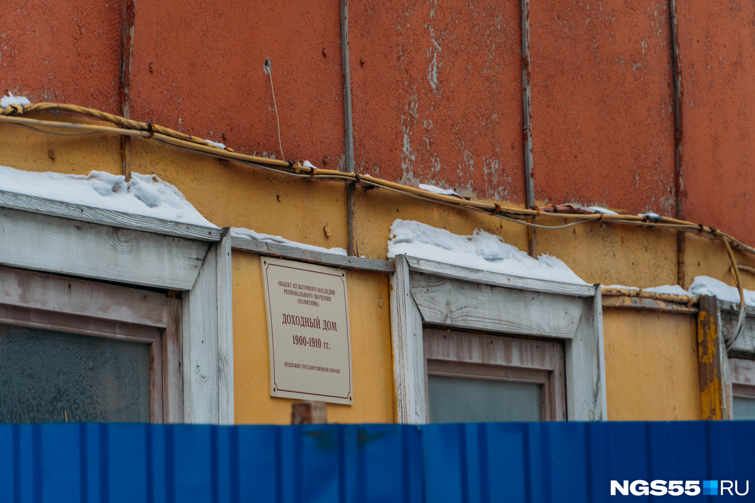 Табличку о том, что дом подлежит государственной охране, видно из-за забора Табличку о том, что дом подлежит государственной охране, видно из-за забора