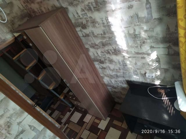 Напротив кухни — стол и вместительный шкаф с зеркалом. В дверном проеме видна лестница в спальню