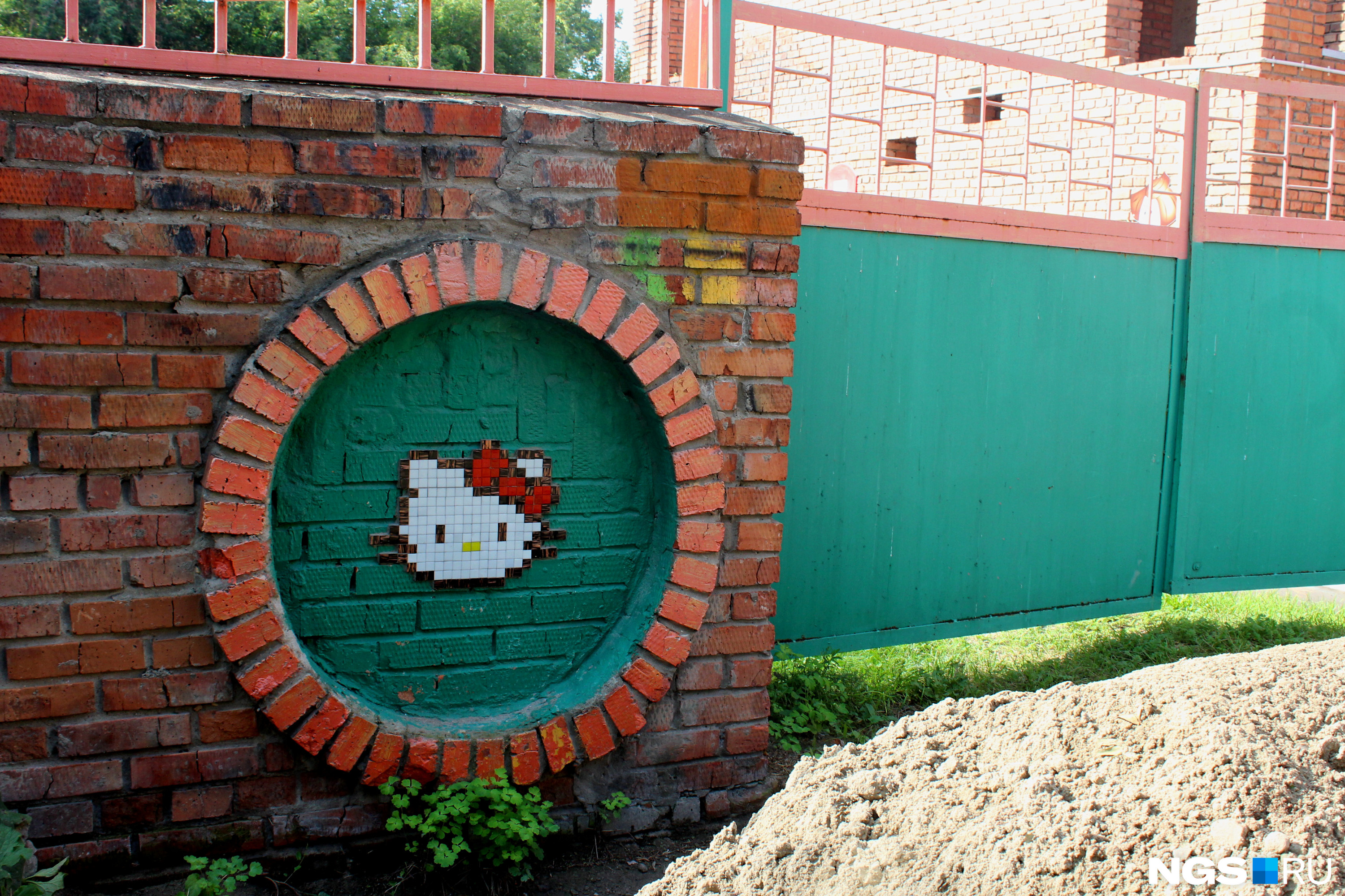 Кошечка Китти на заборе детского сада во дворе на Горького