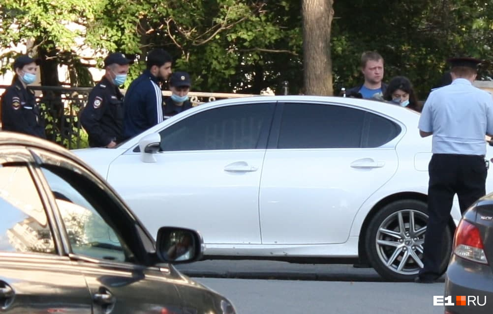 Белый Lexus принадлежит Виктору Цымбалу. Он стоит рядом с машиной в спортивном костюме 