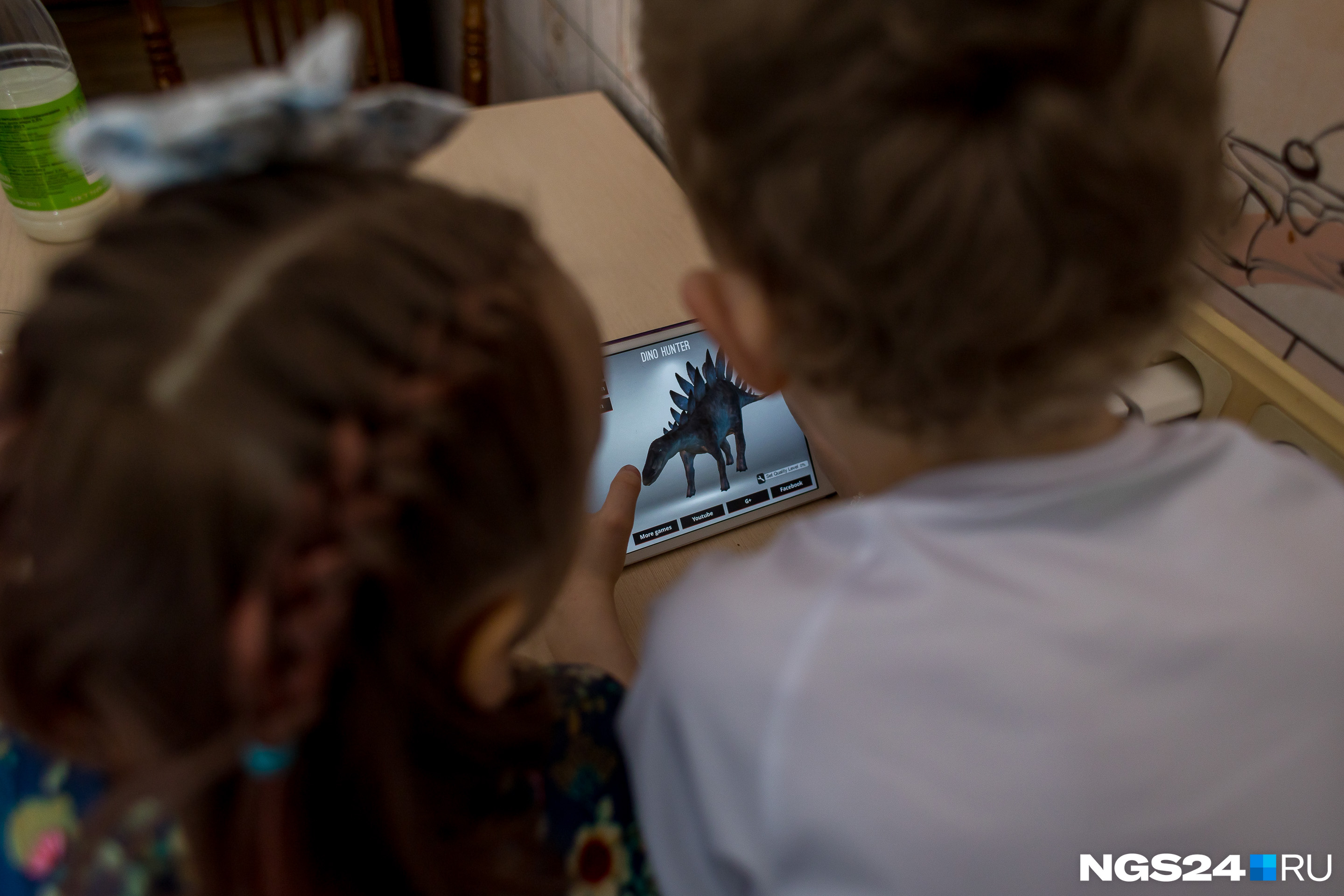 Старший брат показывает младшей сестренке видео про динозавров 