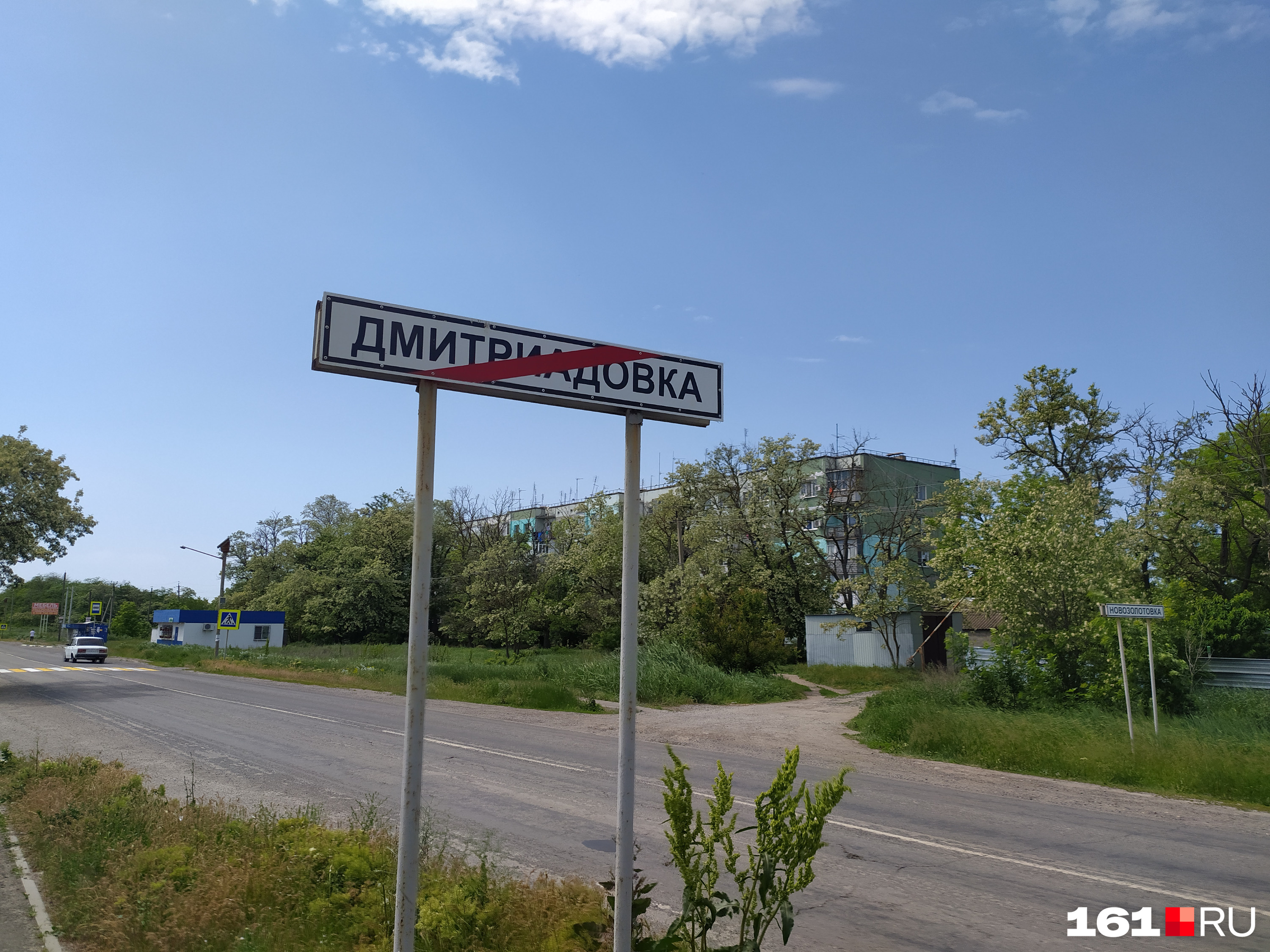 Позади дорожного указателя — единственная в поселке многоэтажка. Ее построили специально по заказу водоканала Позади дорожного указателя — единственная в поселке многоэтажка. Ее построили специально по заказу водоканала