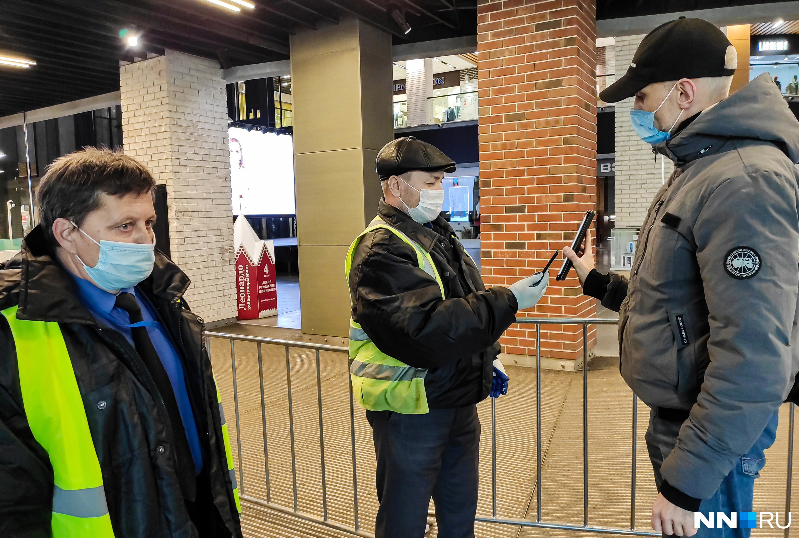 Охранники сканируют QR-код с помощью телефонов