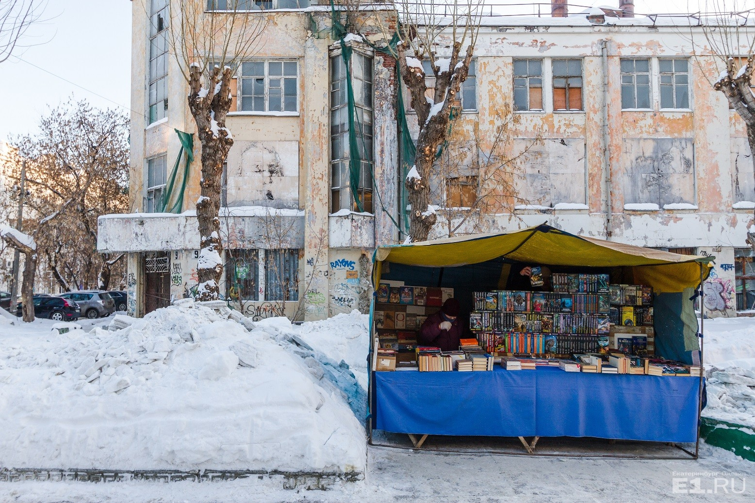 Рядом с заброшенным зданием развернулась палатка, где продают старые книжки и диски.

