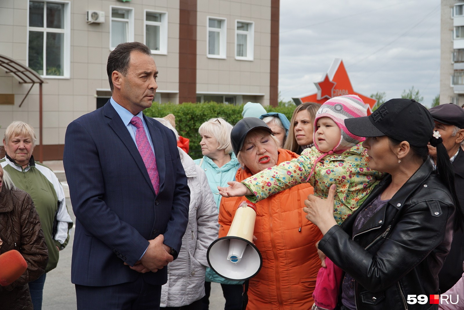 Андрей Миньков и местная жительница, которая пришла на митинг с ребенком 