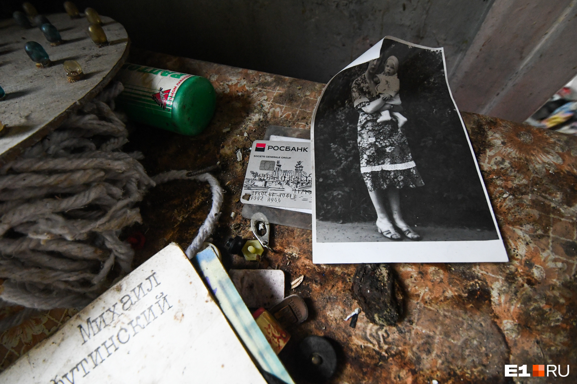 На комоде в коридоре перед мансардой лежат старые фотографии, банковская карта и пластинка Шуфутинского