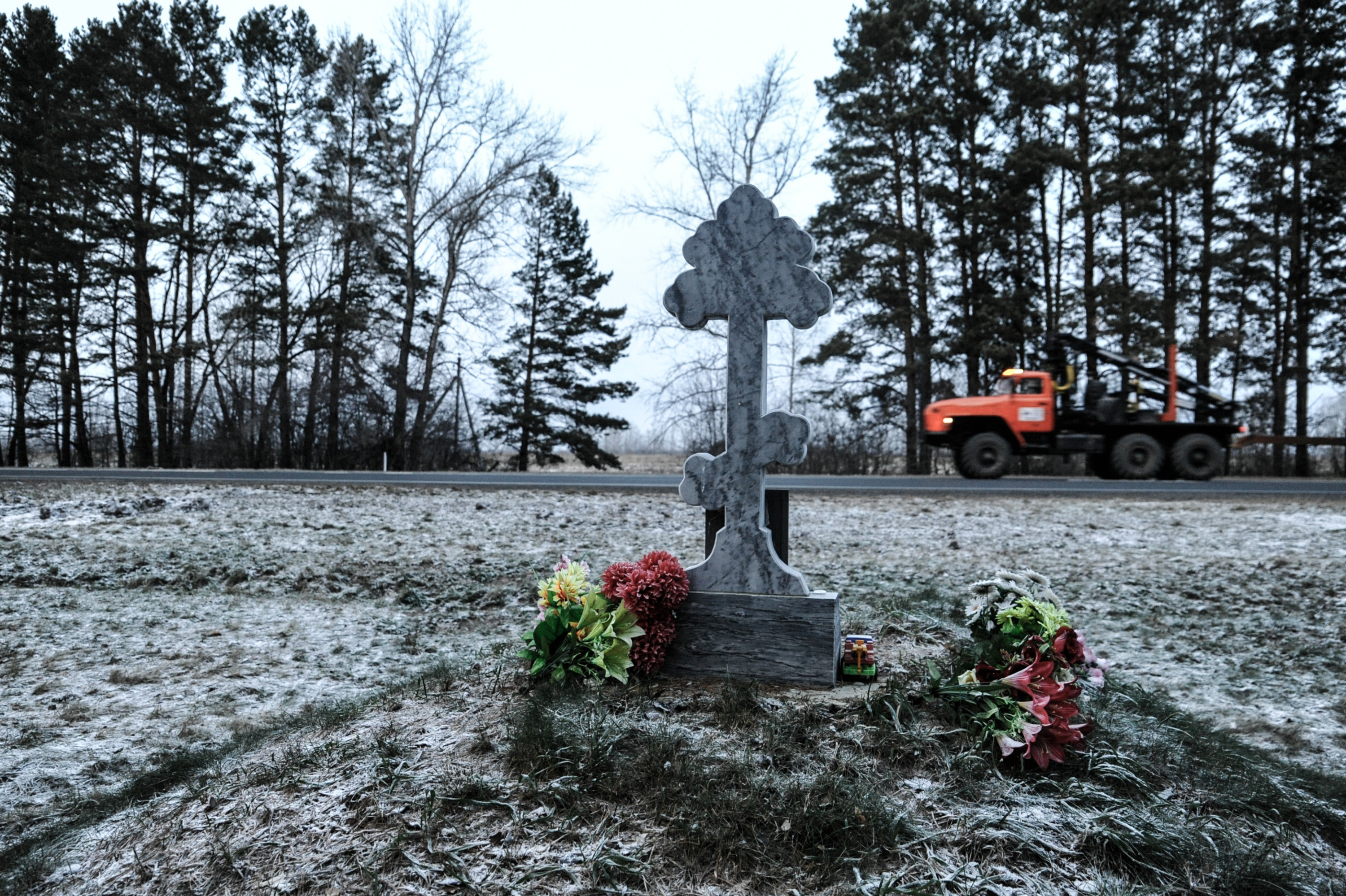 У памятника стоит машинка, лежат искусственные цветы и конфеты. Видно, что за надгробием семилетнему ребенку ухаживают. Родные или проезжающие мимо водители — неизвестно