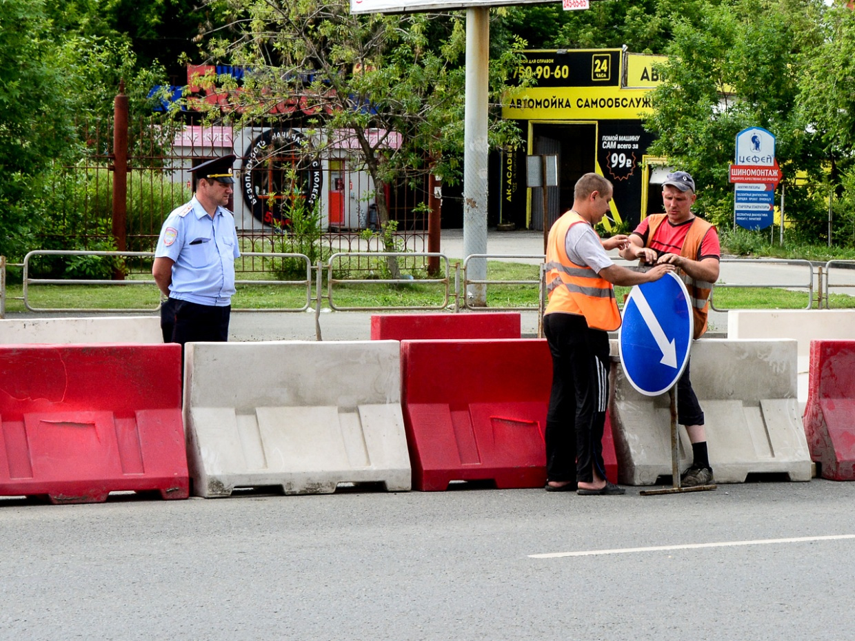 Рабочие устанавливают временный знак, показывающий направление объезда препятствий: он имеет приоритет над разметкой