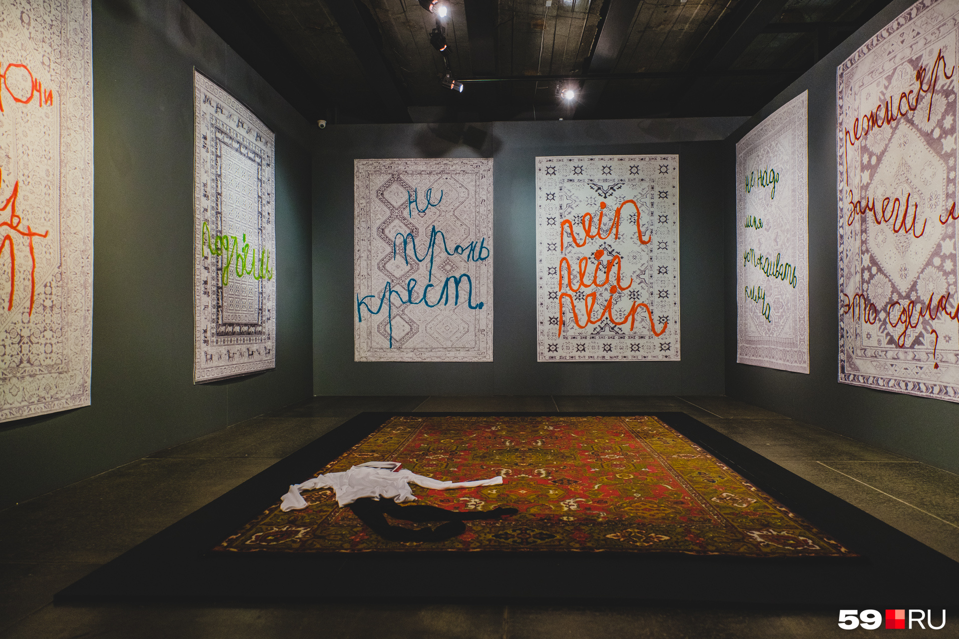 Инсталляция с обесцвеченными коврами и Энди Уорхолом на полу. Цветной ковер — это его «дом» по замыслу ребенка