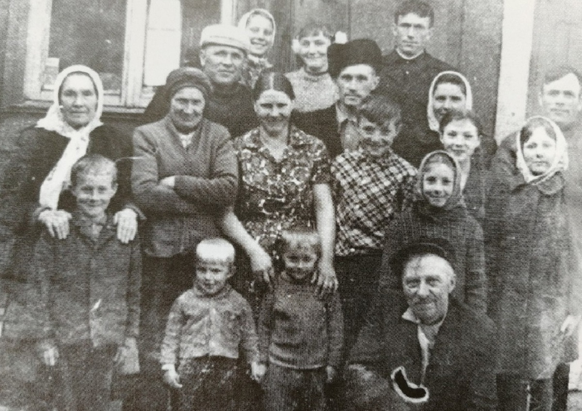 Семья Боссерт на фоне деревянной избы