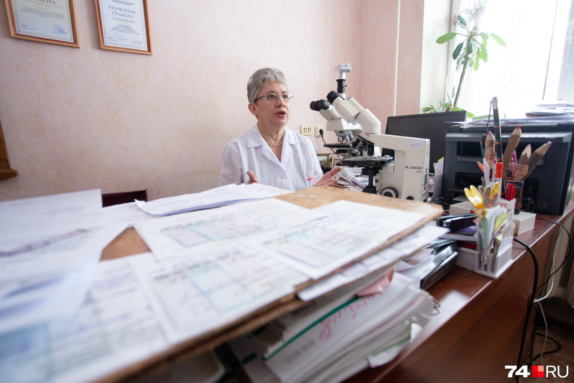 О числе пациентов, которым патологоанатомы помогают поставить диагноз, можно судить по внушительным стопкам карт и стёкол на рабочем столе