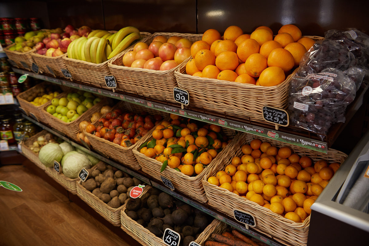 На прилавках магазинов лежат отборные овощи. Овощи на прилавке. Овощной прилавок. Фрукты в магазине. Прилавок с фруктами.