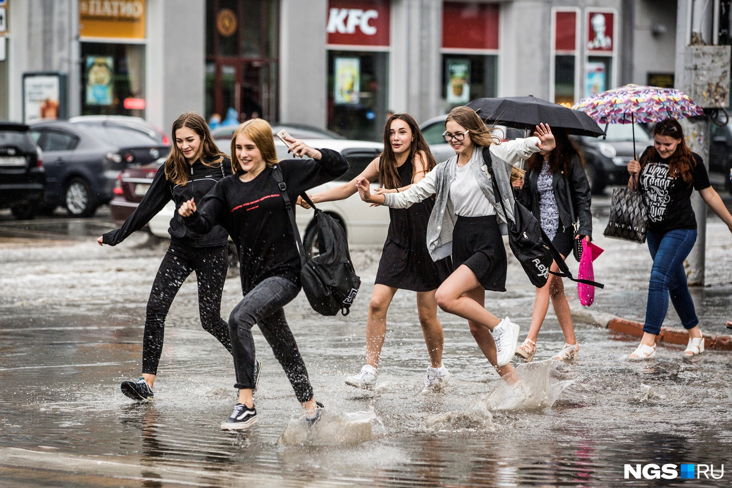 Девушки бегут по пешеходному переходу, который затопил июльский ливень 