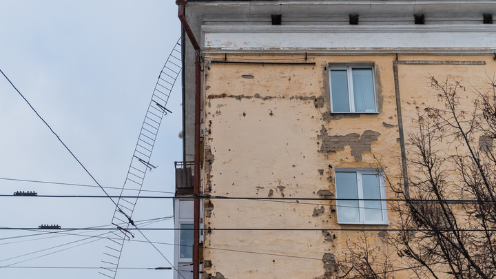 С крыши дома на Комсомольском проспекте свисают металлические перила