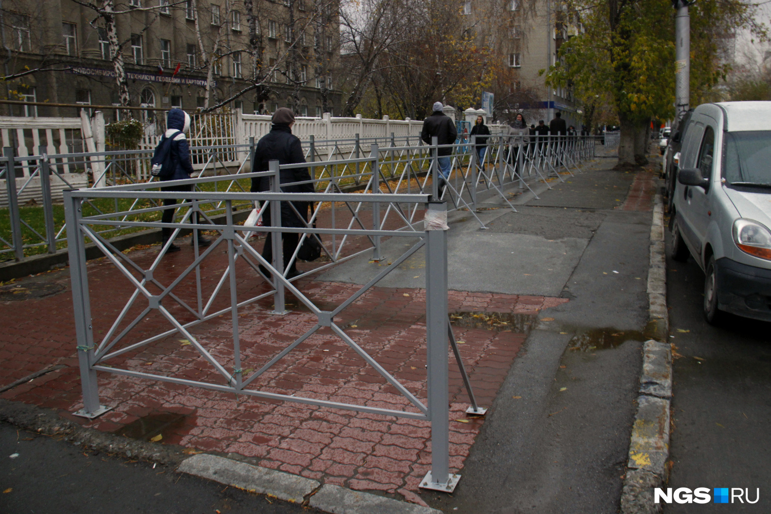 Забор на улице Крылова, ограждающий часть тротуара от пешеходов