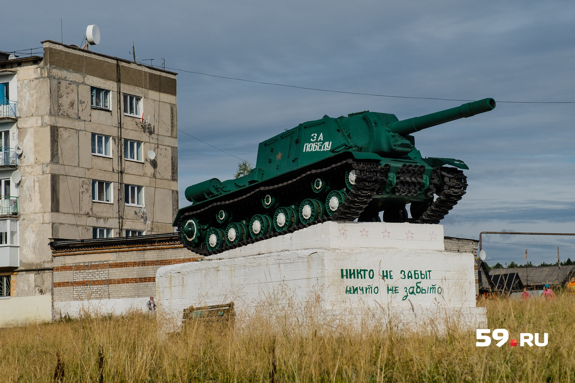 Возле разрушенных зданий — памятник, посвященный Великой Отечественной войне