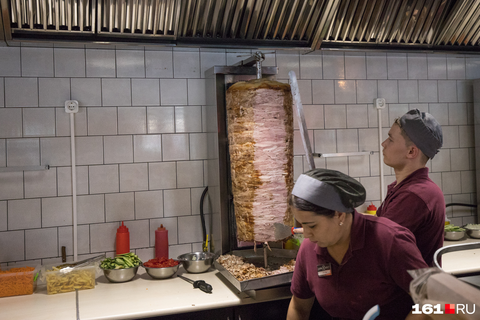 Сотрудники режут мясо на открытой кухне 