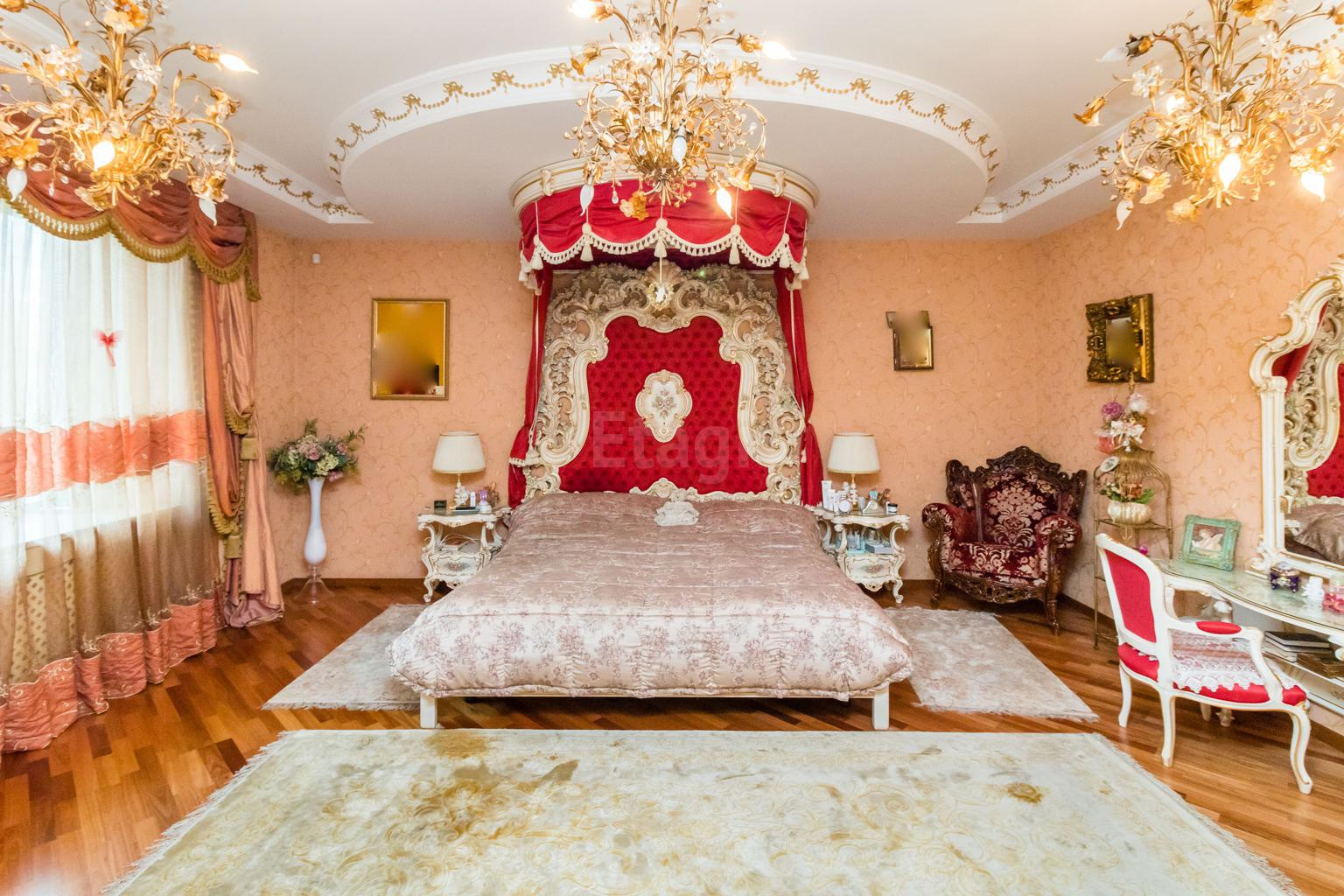 В одной из спален многоуровневый потолок, шторы с ламбрекенами и золотые люстры