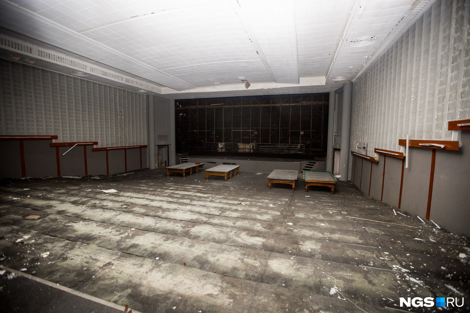 Пустой зрительный зал с бильярдными столами у экрана