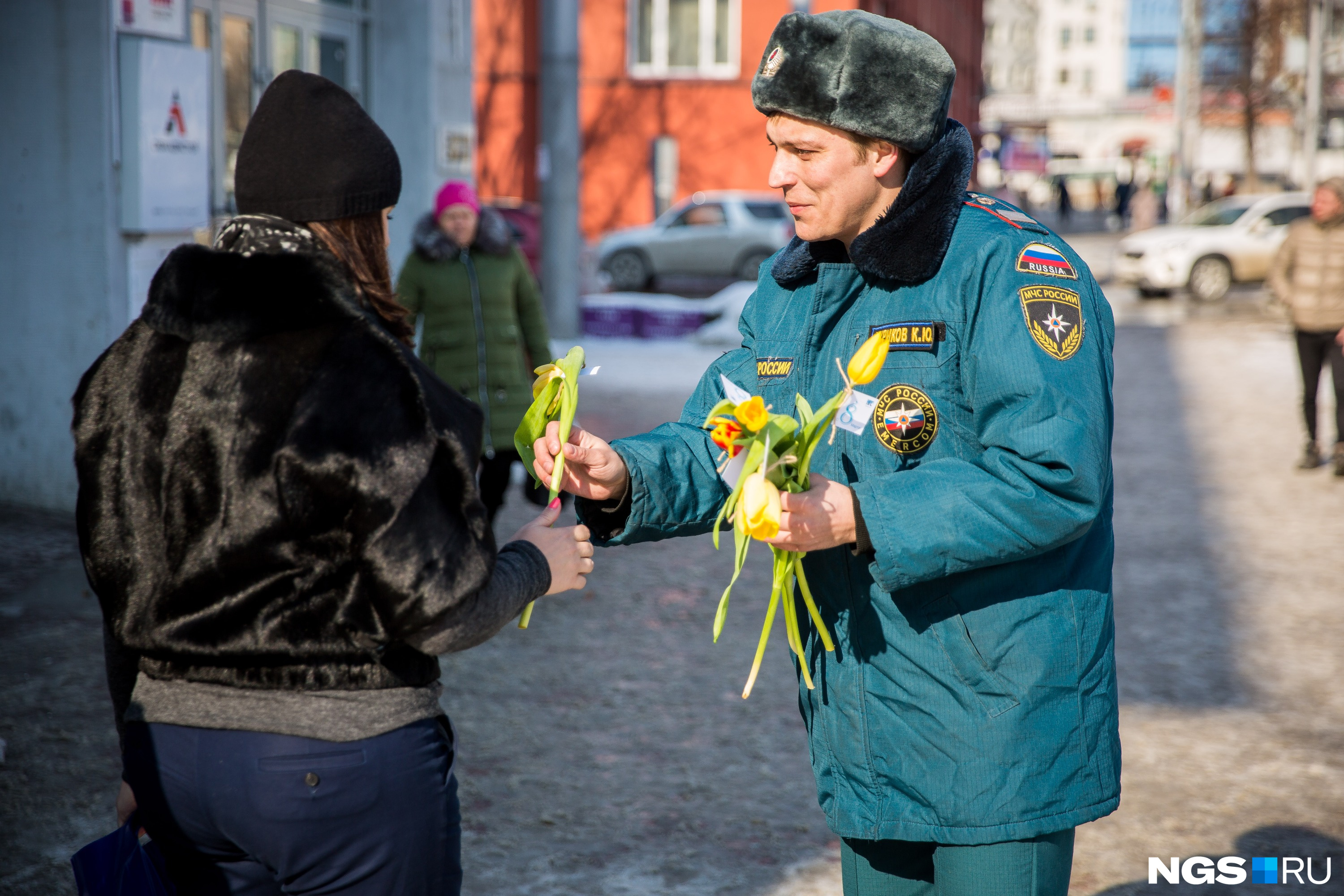 Пожарный Кирилл Чуриков дарит цветы сибирячкам на площади Ленина