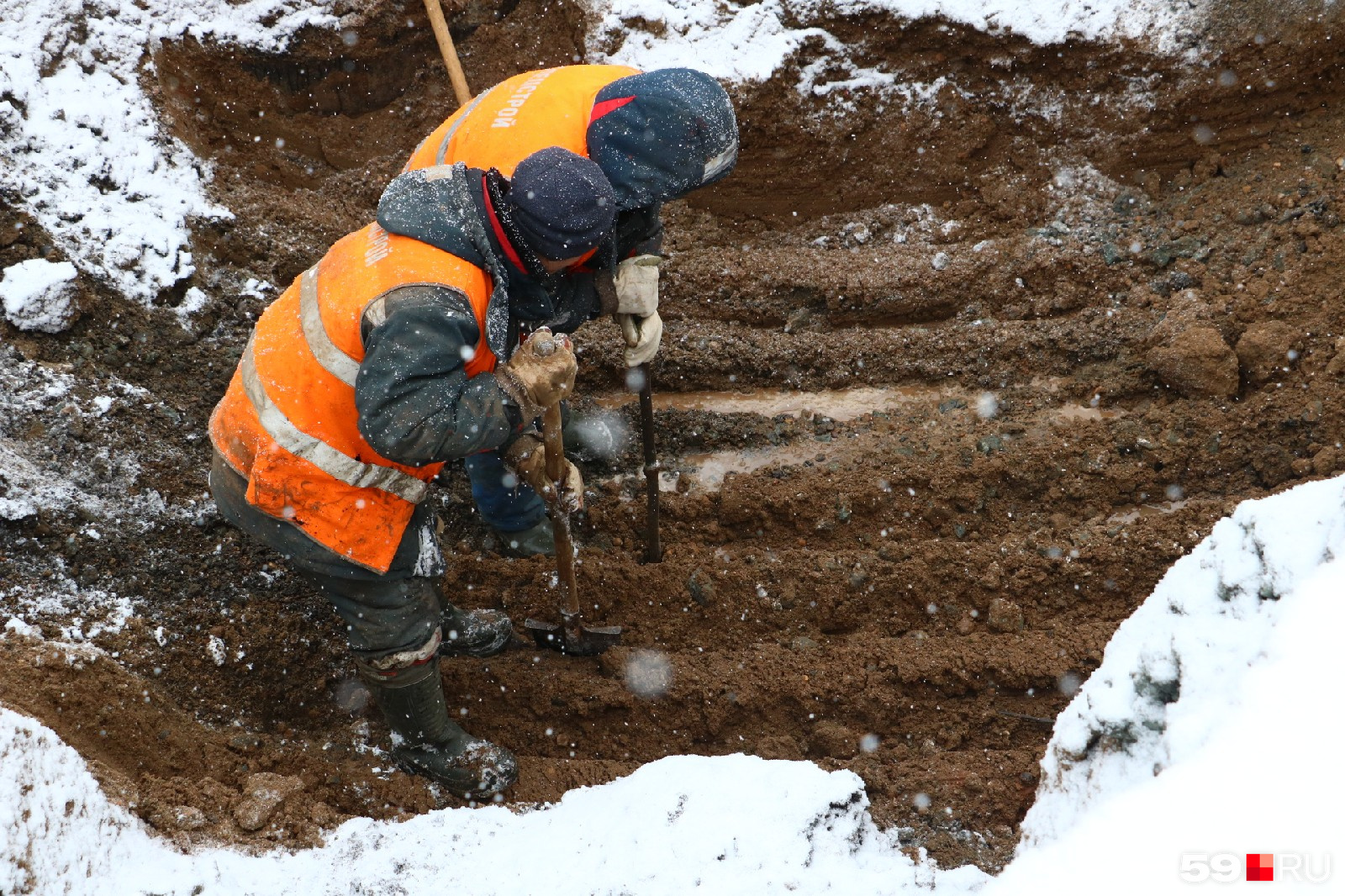 Рабочие копают землю, чтобы добраться до трубы