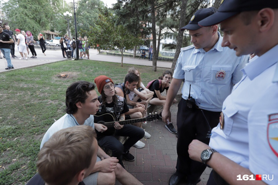 Несколько молодых людей отвечают на вопросы полицейских 