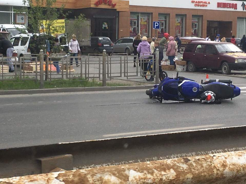 Под мотоциклом лежит самокат пострадавшей девушки, которая везла его по переходу 
