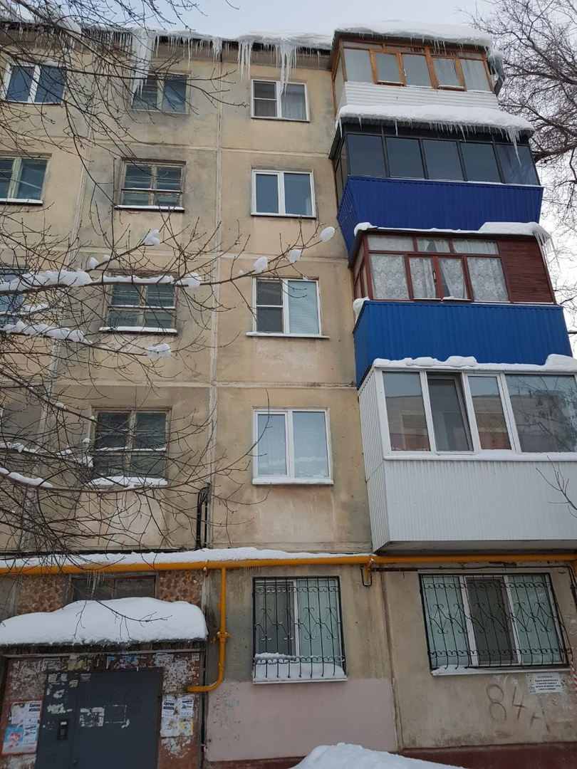 Снежная шапка свивает с крыши и козырька балконов Снежная шапка свивает с крыши и козырька балконов