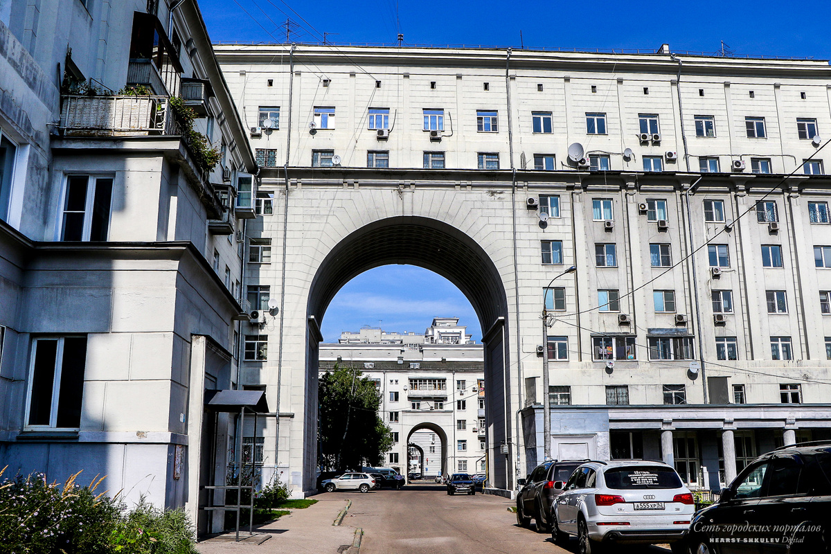 Сквозь серый дом проходят арки высотой в три этажа Сквозь серый дом проходят арки высотой в три этажа